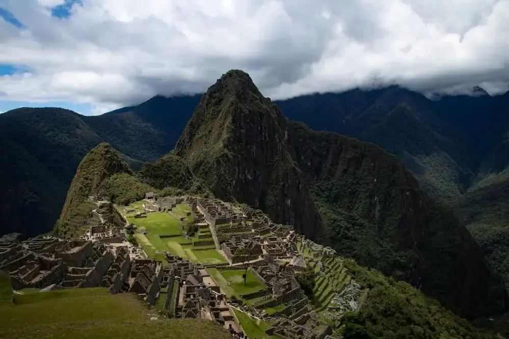 Panoramic view of Machu Picchu, the ancient Inca citadel surrounded by green Andean mountains in Peru. | Andean Travel Experience Panoramic view of Machu Picchu, the ancient Inca citadel surrounded by green Andean mountains in Peru. | Andean Travel Experience